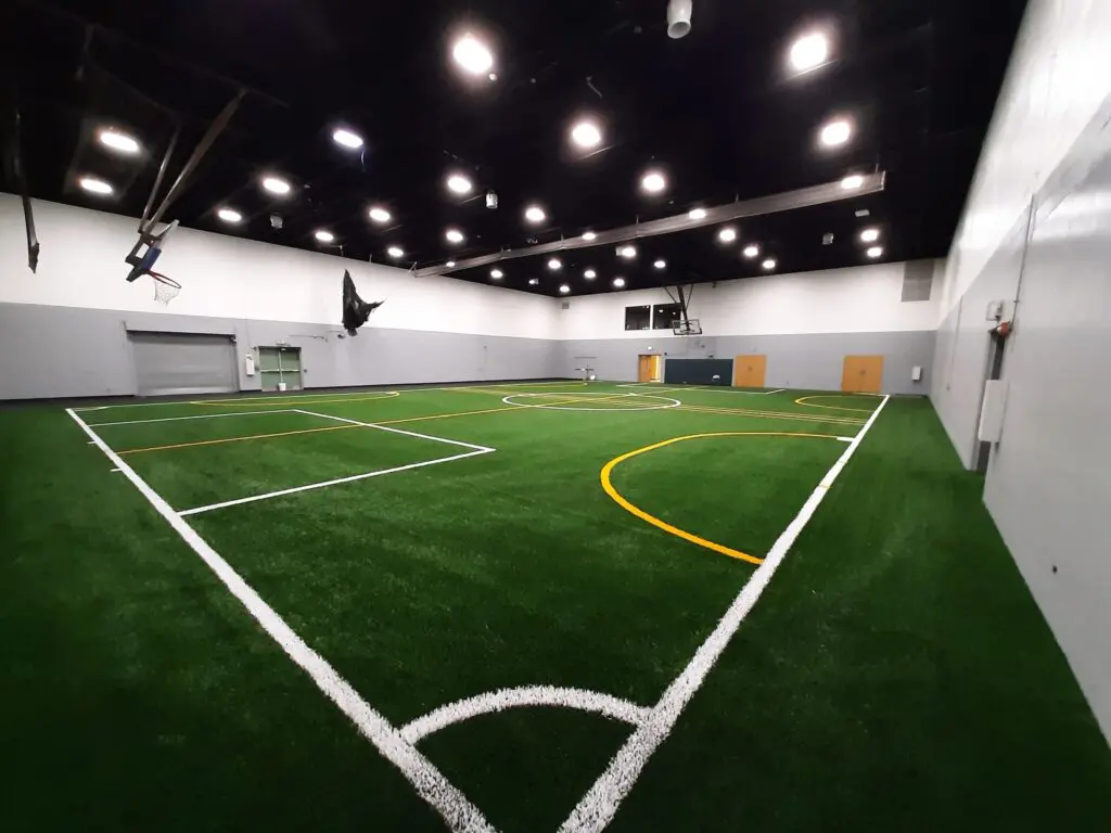 a indoor football field with white lines and a black ceiling