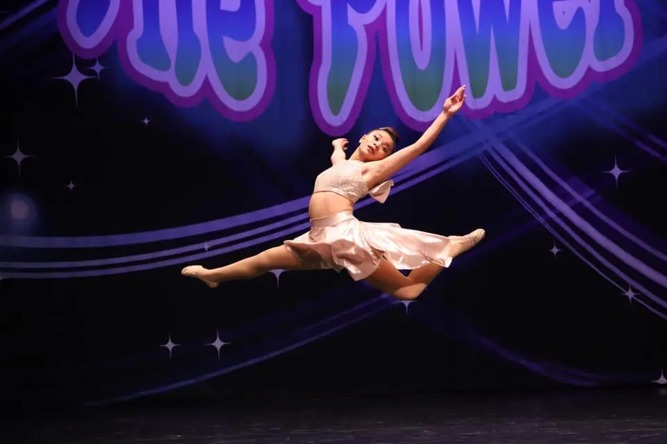 a person in a pink dress dancing on a stage
