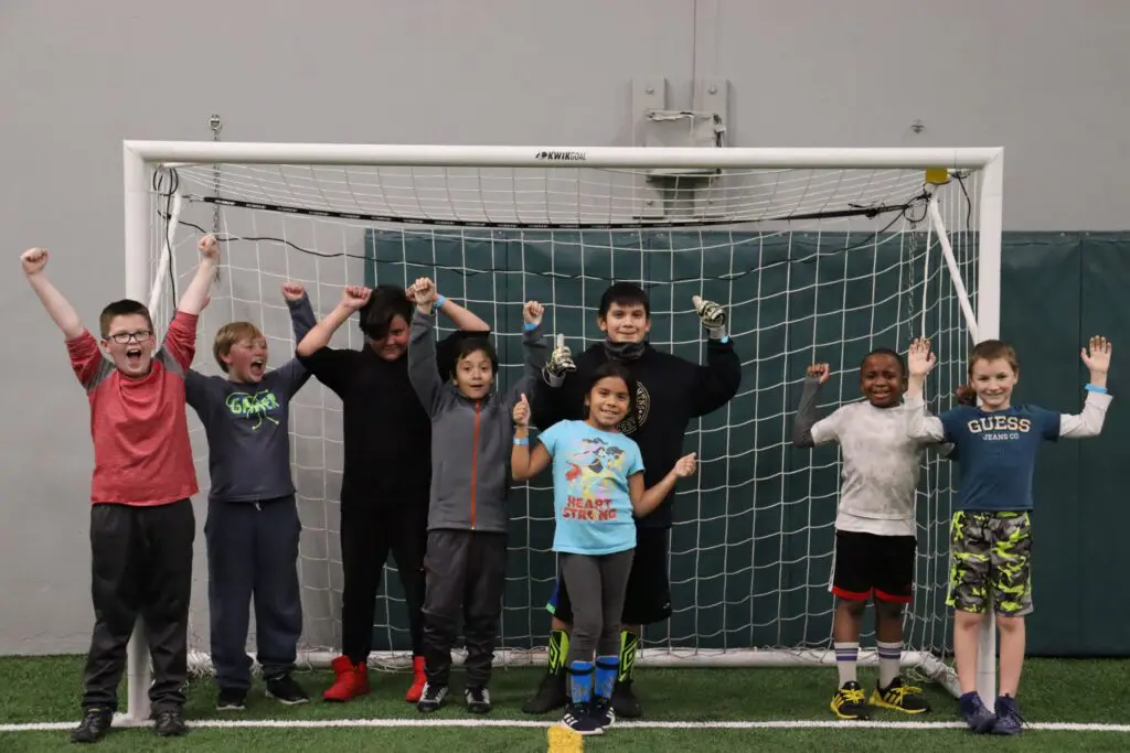 a group of kids standing in front of a goal