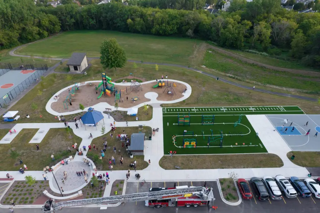 aerial view of a park with playgrounds and cars and trees