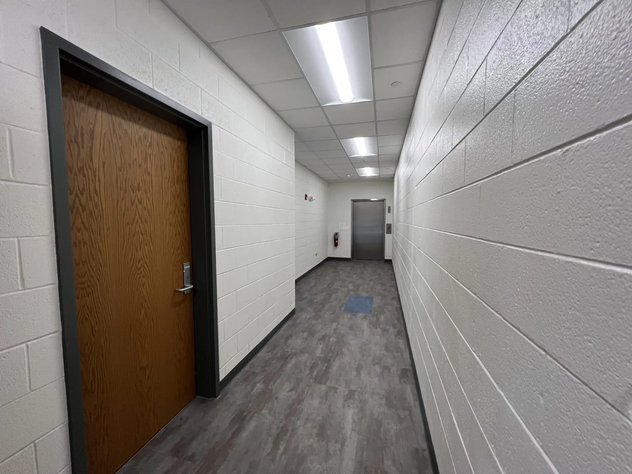 a hallway with a door and a wood door