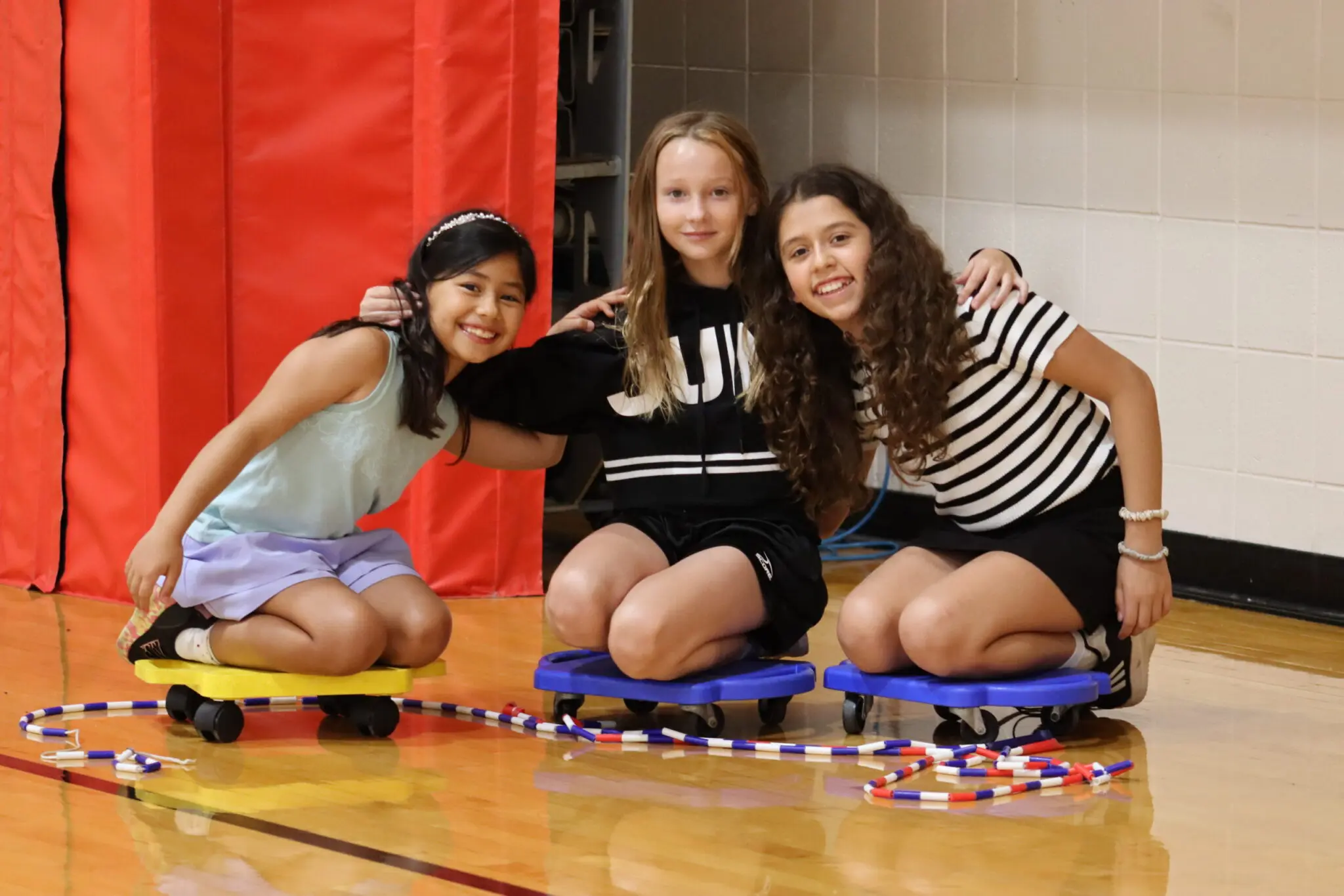 a group of childs sitting on small skateboards