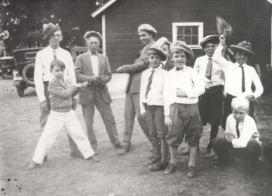a group of childs and a person holding a stick