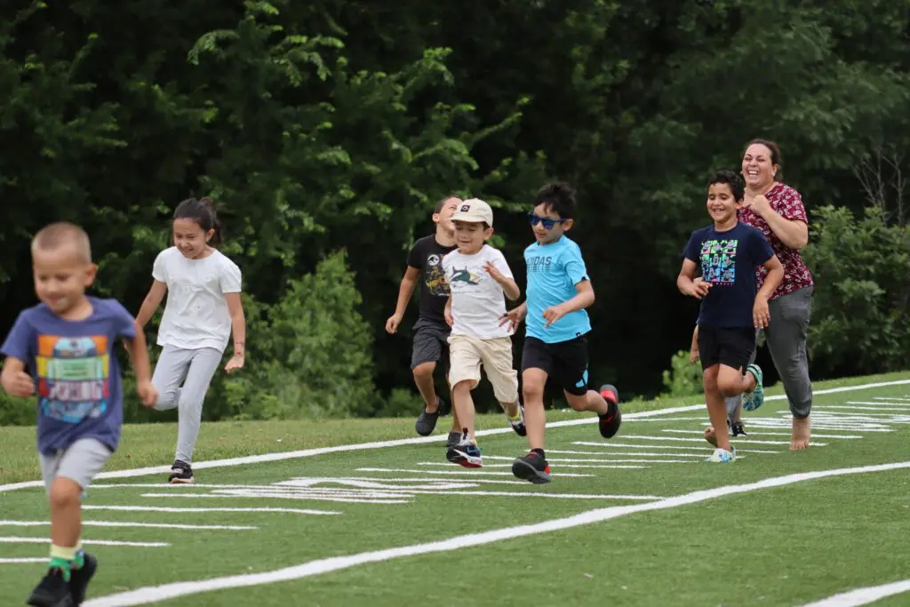 a group of kids running on a field