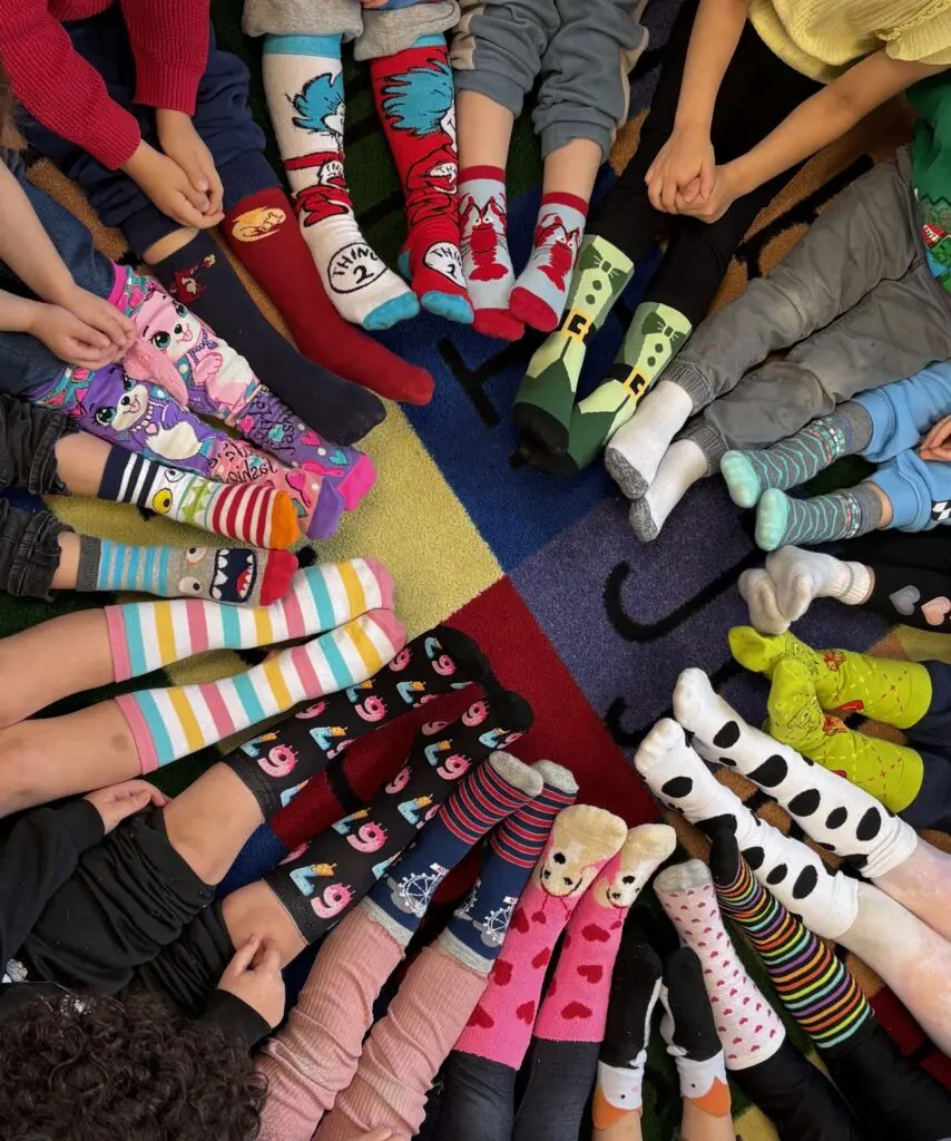 a group of children's legs in a circle with socks