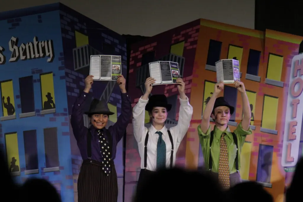 a group of people holding up books