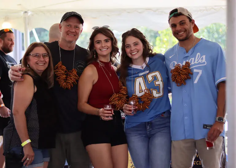 family of 5 posing with small beer glasses and pretzel necklaces