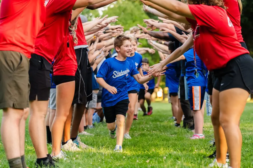 kids running through a tunnel of adults