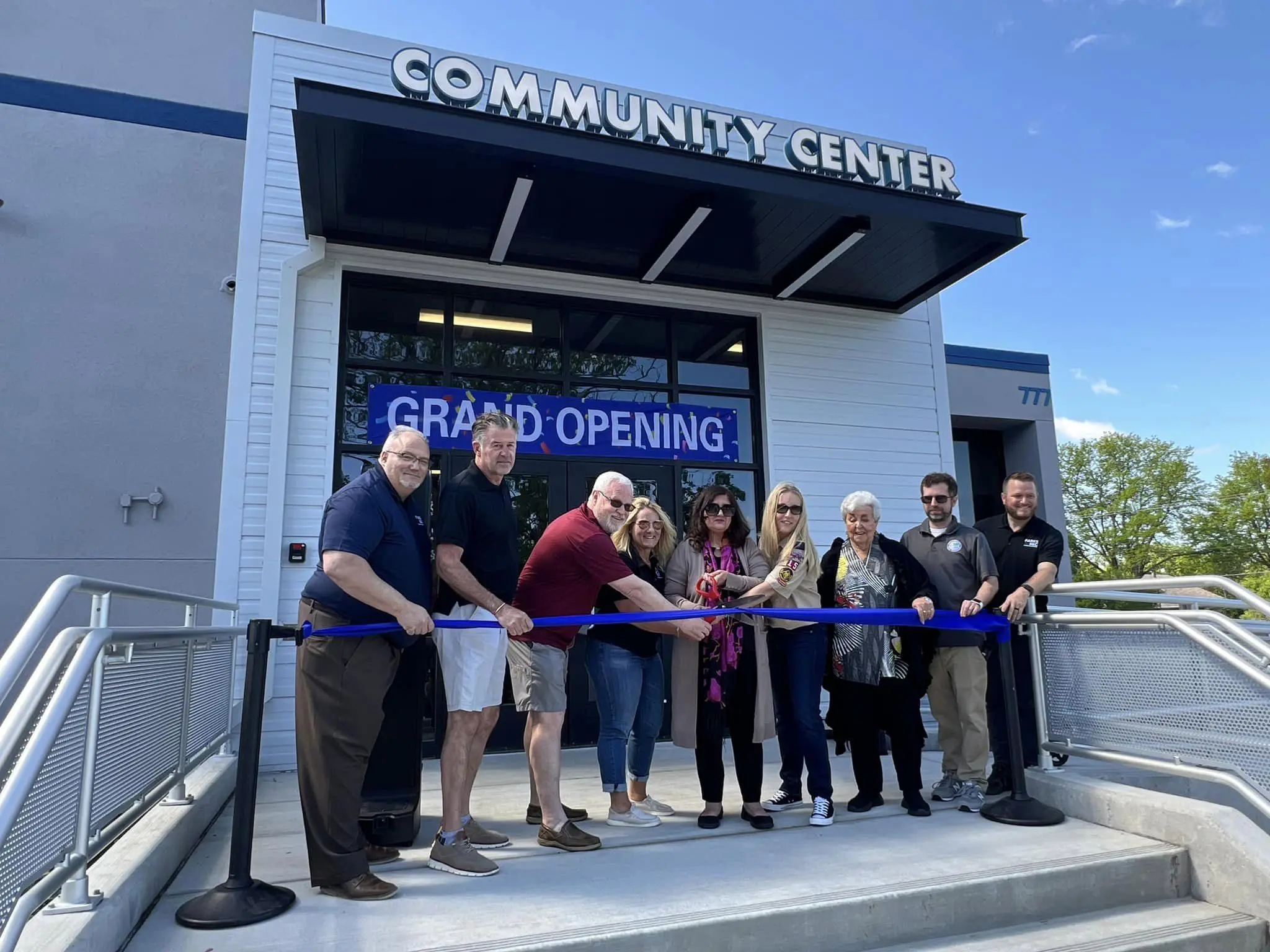 people cutting ribbon for grand opening ceremony