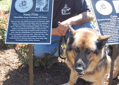 man with German Shepherd dog at Freedom Run Dog Park Memorial Sign