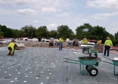 men repairing community center roof